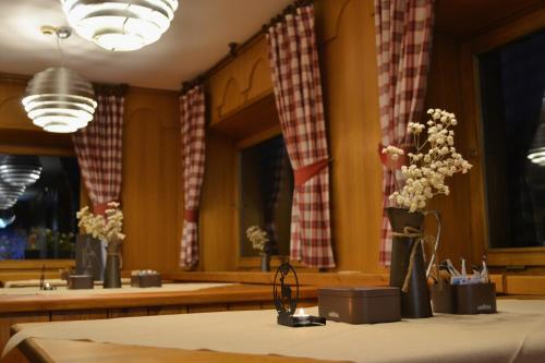 a room with vases of flowers on a table at Hotel Teola in Livigno