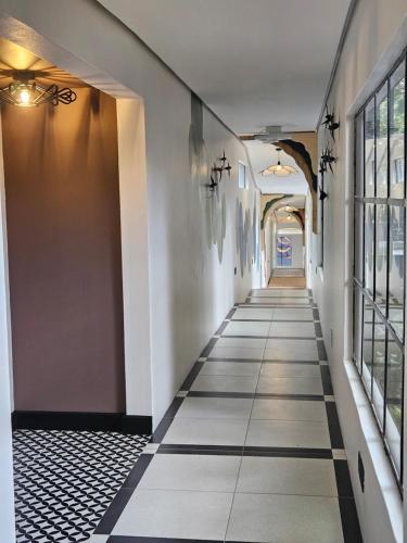 a hallway with black and white tile floors and windows at Amoya Villa in St Lucia