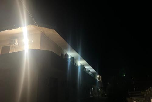a building with lights on the side of it at Albergo Ristorante Bar Pizzeria La Lanterna in Santi Cosma e Damiano