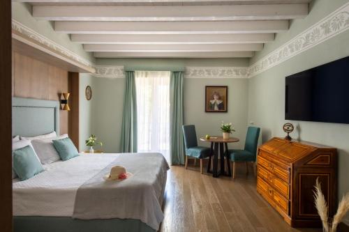 a bedroom with a bed and a tv and a table at Palazzo De Gregorio - Apartments in Palermo
