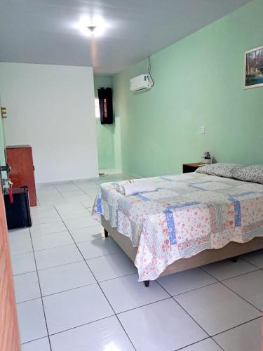 a bedroom with a bed and a green wall at Aguapé quarto 3 in Barreirinhas
