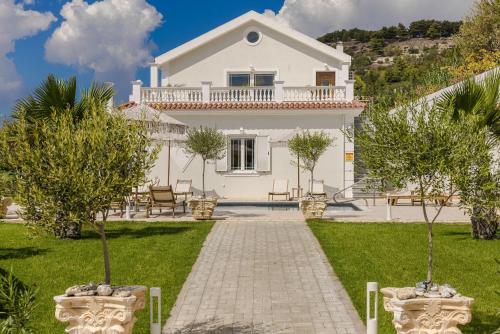 a white house with trees in the yard at Pantheon Villa Svoronata in Svoronata
