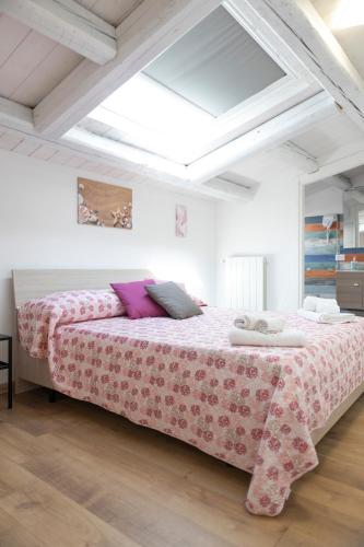 a bedroom with a large bed with a pink blanket at L'Oasi del Tirreno in Lascari