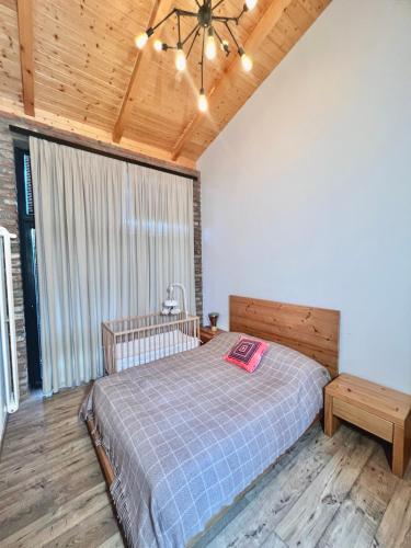 a bedroom with a bed and a wooden ceiling at Chateau Artwine in Art'ana