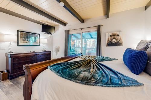 a bedroom with a large bed and a window at Moose-in' Around ~ Walk to Slopes Mountain Home with Private Hot Tub, Ski Locker & Playground in Big Bear Lake