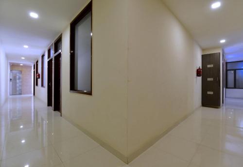 a hallway of a building with white floors and windows at Hotel O Heritage Haveli in Jaipur