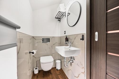 a bathroom with a sink and a toilet and a mirror at Plavírna in Otovice