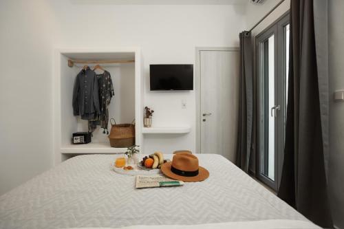 a hat and fruit on a bed in a bedroom at CasaNova Luxury Apartment in Naxos Chora
