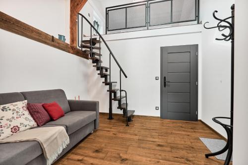 a living room with a couch and a staircase at Plavírna in Otovice