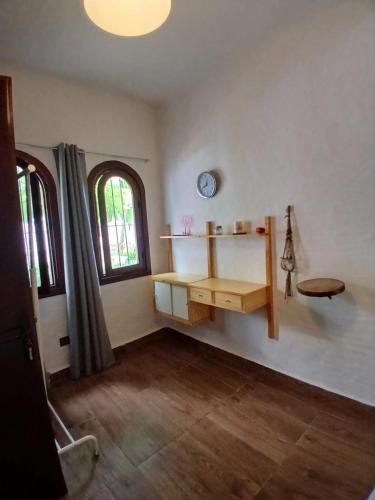 a room with a desk and a clock on the wall at Coastal Elegance in Oulad Akkou