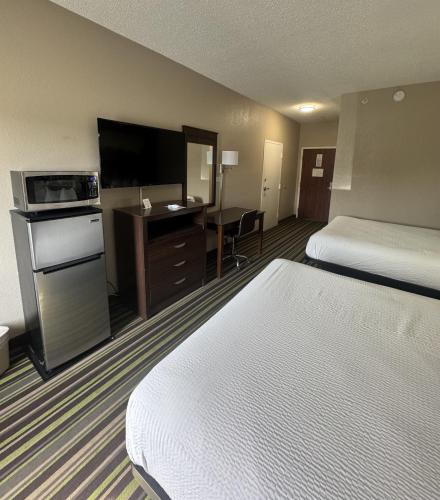 a hotel room with two beds and a flat screen tv at Super 8 by Wyndham Hernando in Hernando