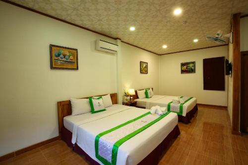 a hotel room with two beds in a room at Bamboo Hotel Phu Quoc in Phu Quoc