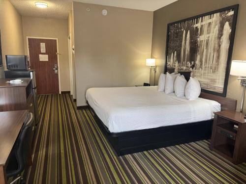 a hotel room with a large bed with white pillows at Super 8 by Wyndham Hernando in Hernando