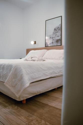 a bedroom with a bed with white sheets and pink pillows at Hotel Ramos Mejía in Mar del Plata