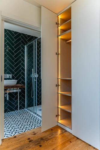a bathroom with a glass door leading to a sink at Celtic Lodge - Guest House in Viseu