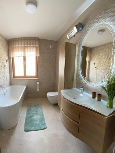 a bathroom with a tub and a sink and a mirror at Luxury Beachfront Villa Bregeš - First row to the sea in Povljana