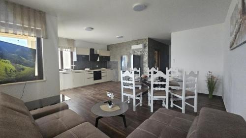 a living room with a couch and a table and a kitchen at Luxury Beachfront Villa Bregeš - First row to the sea in Povljana