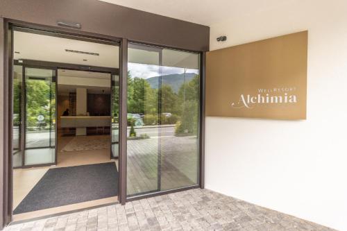 an entrance to a building with a sign on the wall at Alchimia WellResort in Comano Terme