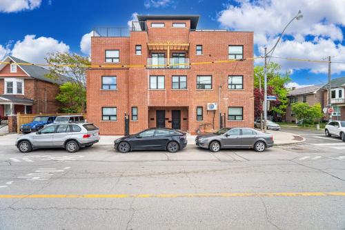 three cars parked in a parking lot in front of a brick building at Mins from Toronto Downtown UFT Exhibition Place in Toronto