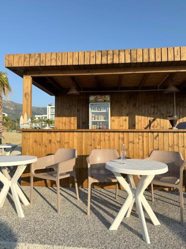ヴロラにあるBaro Beach Hotelの建物の前のテーブルと椅子のあるパティオ