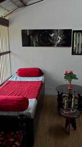 a bedroom with a bed and a table in it at Tropical Whisper in Nagaon