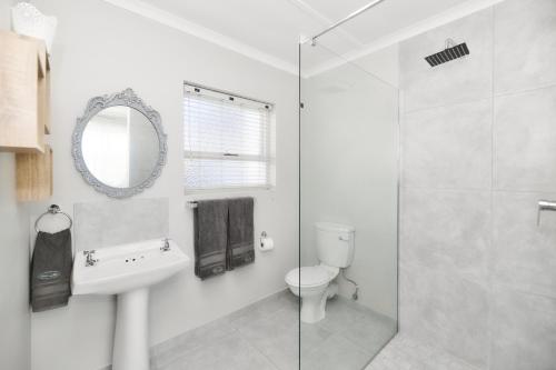 a bathroom with a sink toilet and a mirror at Hugo Haven in Bredasdorp
