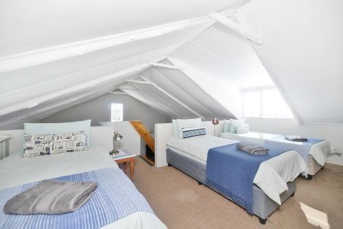 two beds in a room with a attic at Hugo Haven in Bredasdorp