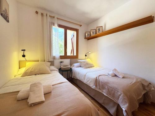 una camera da letto con due letti e una finestra di C09 - Apartamento Pirineos - Villmor a Cerler