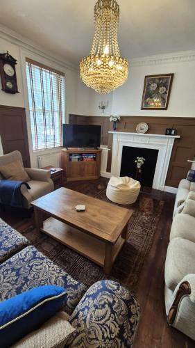 a living room with a coffee table and a chandelier at Beautiful 4BR Georgian house in Wisbech