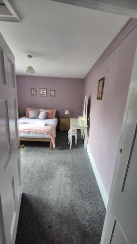 a bedroom with a bed and a desk in it at Beautiful 4BR Georgian house in Wisbech