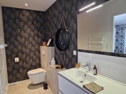 a bathroom with a toilet and a sink at La Moutonne des Landes de Lanvaux in Saint-Jacut-les-Pins