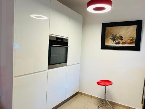 a kitchen with white cabinets and a red stool at Ferienhaus Schott Prichsenstadt in Prichsenstadt