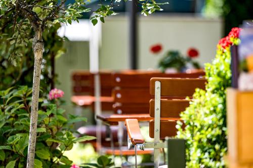 a group of benches in a garden with flowers at Ruhpoldinger Hof - Hotel & Wellness in Ruhpolding