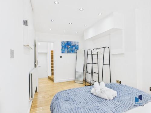 a bedroom with a bed with two white towels at Modern 4BR House, Spacious, Garden, Free Parking in Purley