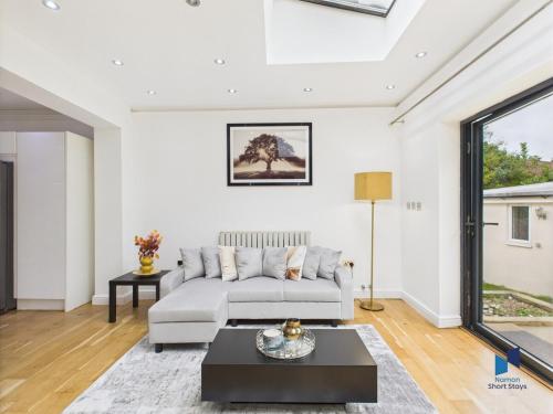 a living room with a couch and a table at Modern 4BR House, Spacious, Garden, Free Parking in Purley