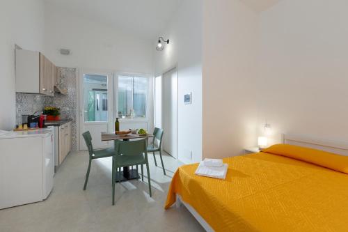 a bedroom with a bed and a table and a kitchen at Azienda Agrituristica Spicchio di Sole in Bernalda