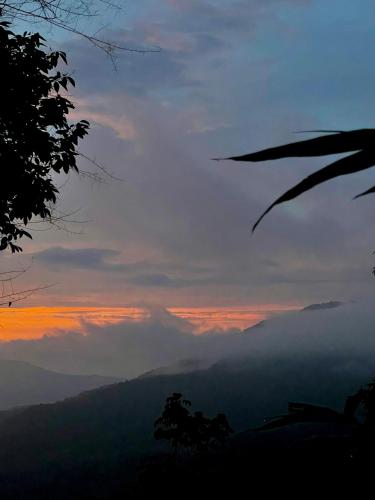 a sunset in the mountains with clouds in the sky at Minca Ecohabs Hotel in Minca