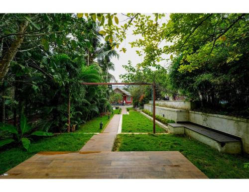 a path in a park with benches and trees at Pvs villa in Bekal