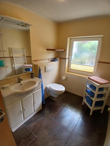 a bathroom with a sink and a toilet and a window at Bungalow in Kühlungsborn in Kühlungsborn