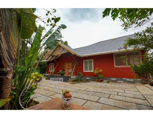 a red house with a patio in front of it at Pvs villa in Bekal