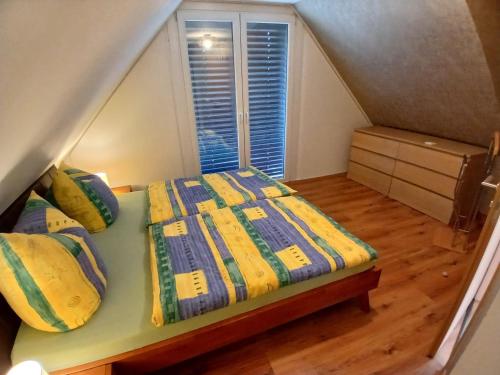 a bedroom with a bed with a yellow and blue comforter at Bungalow in Kühlungsborn in Kühlungsborn