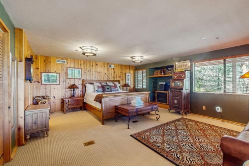 a bedroom with a bed in a room with wooden walls at Big Bear 7th Heaven ~ Lakeview Chalet with Hot Tub, Sauna, Grill, Great Deck Views in Fawnskin