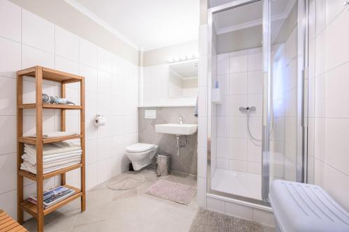a bathroom with a shower and a toilet and a sink at Landhaus Hindenburg in Bad Gleichenberg