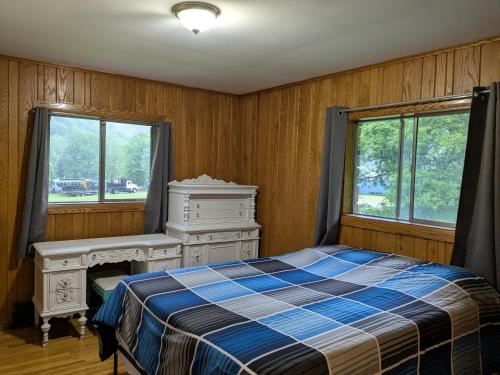 a bedroom with a bed and a desk and windows at Scenic Solitude in Dryfork