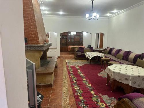 a living room with a couch and a table at Ferme avec piscine et vue panoramique in Khenifra