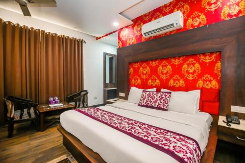a bedroom with a large bed with a red headboard at Hotel Royals Grand Galaxy in Amritsar