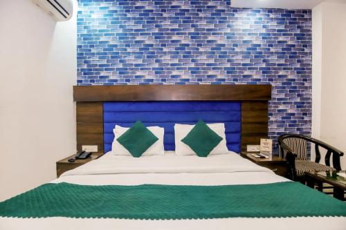 a bedroom with a bed with a blue brick wall at Hotel Royals Grand Galaxy in Amritsar