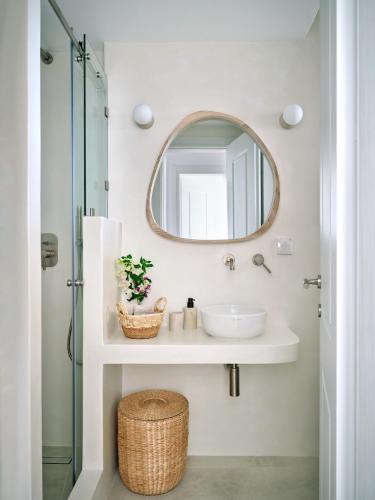 a bathroom with a sink and a mirror at Parian Pearl Unique SeaView in Naousa