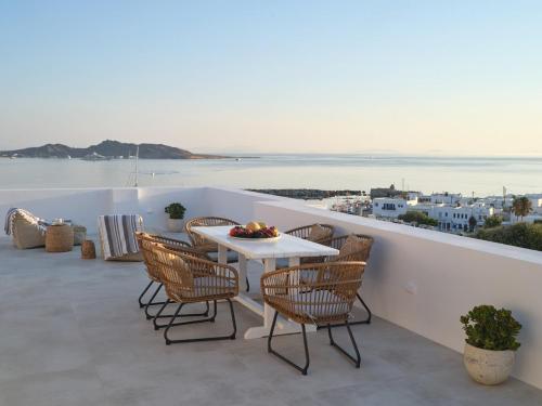 a table and chairs on a balcony with a view of the water at Parian Pearl Unique SeaView in Naousa