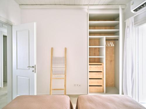 two beds in a room with a closet at Parian Pearl Unique SeaView in Naousa